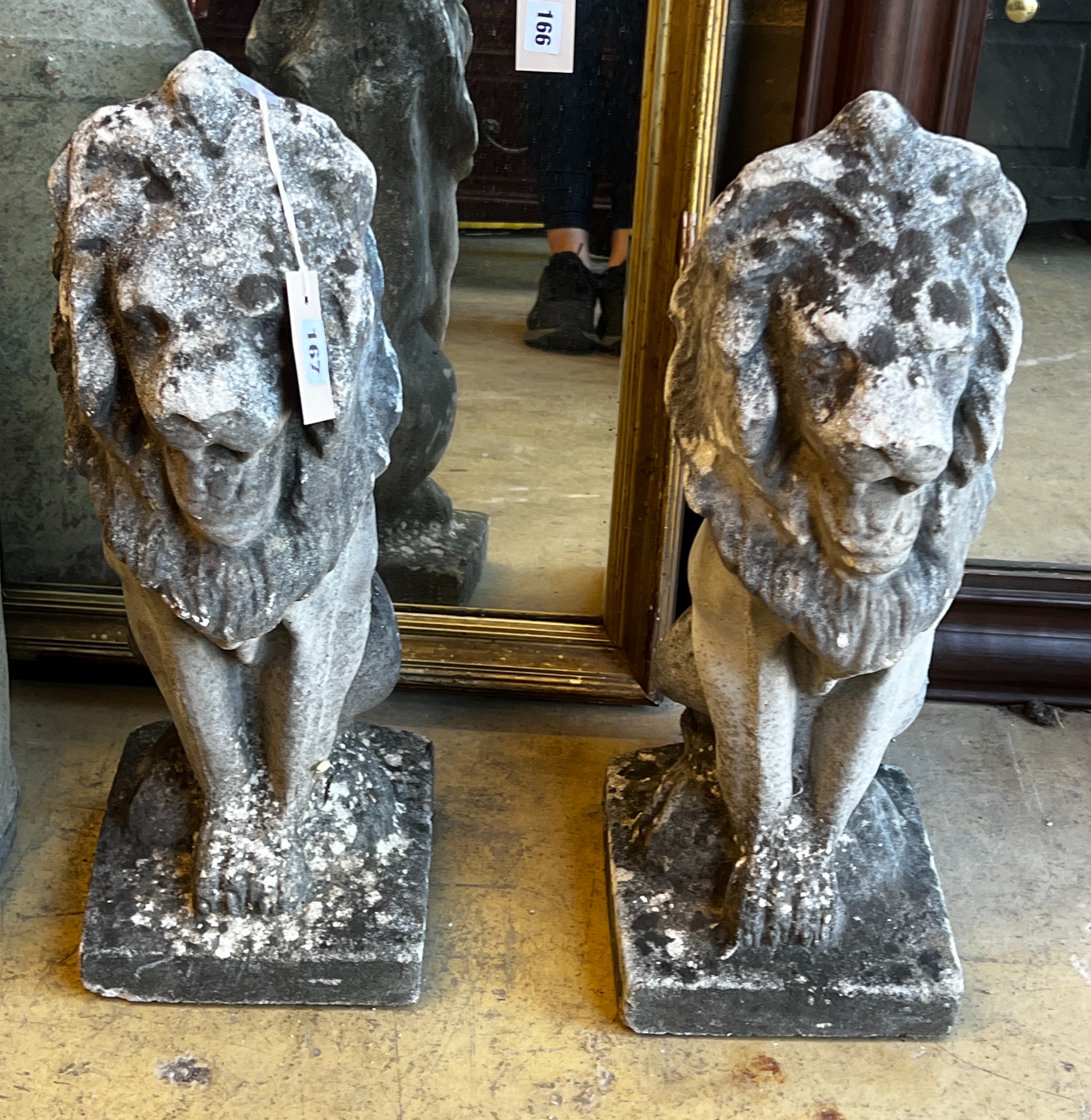 A pair of reconstituted stone seated lion garden ornaments, height 55cm